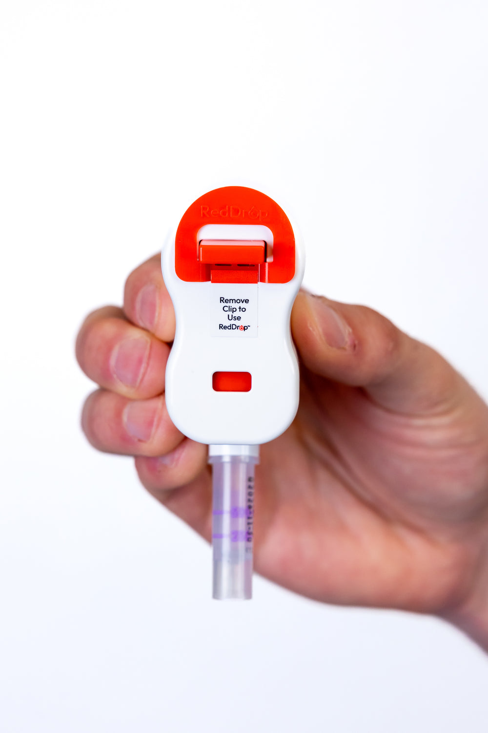 Hand holding RedDrop ONE capillary blood collection device with attached tube